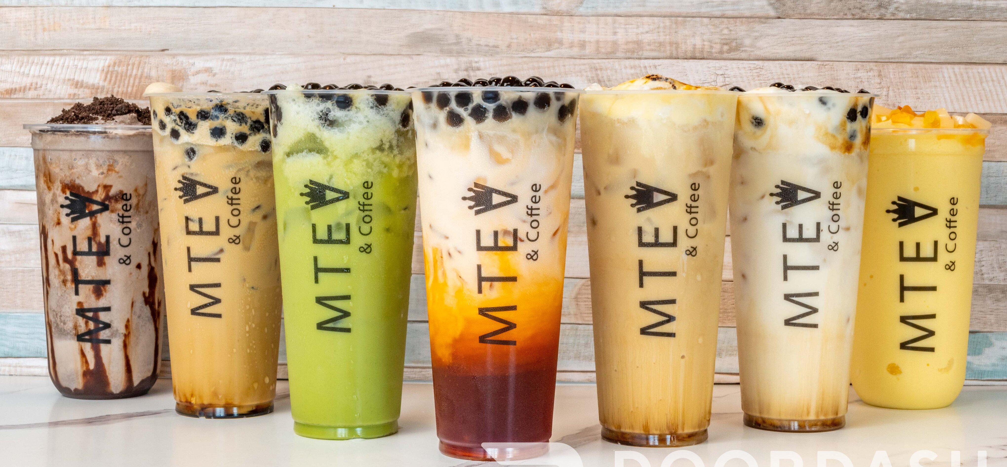 Selection of MTea’s signature boba, coffee, and smoothie drinks lined up horizontally.