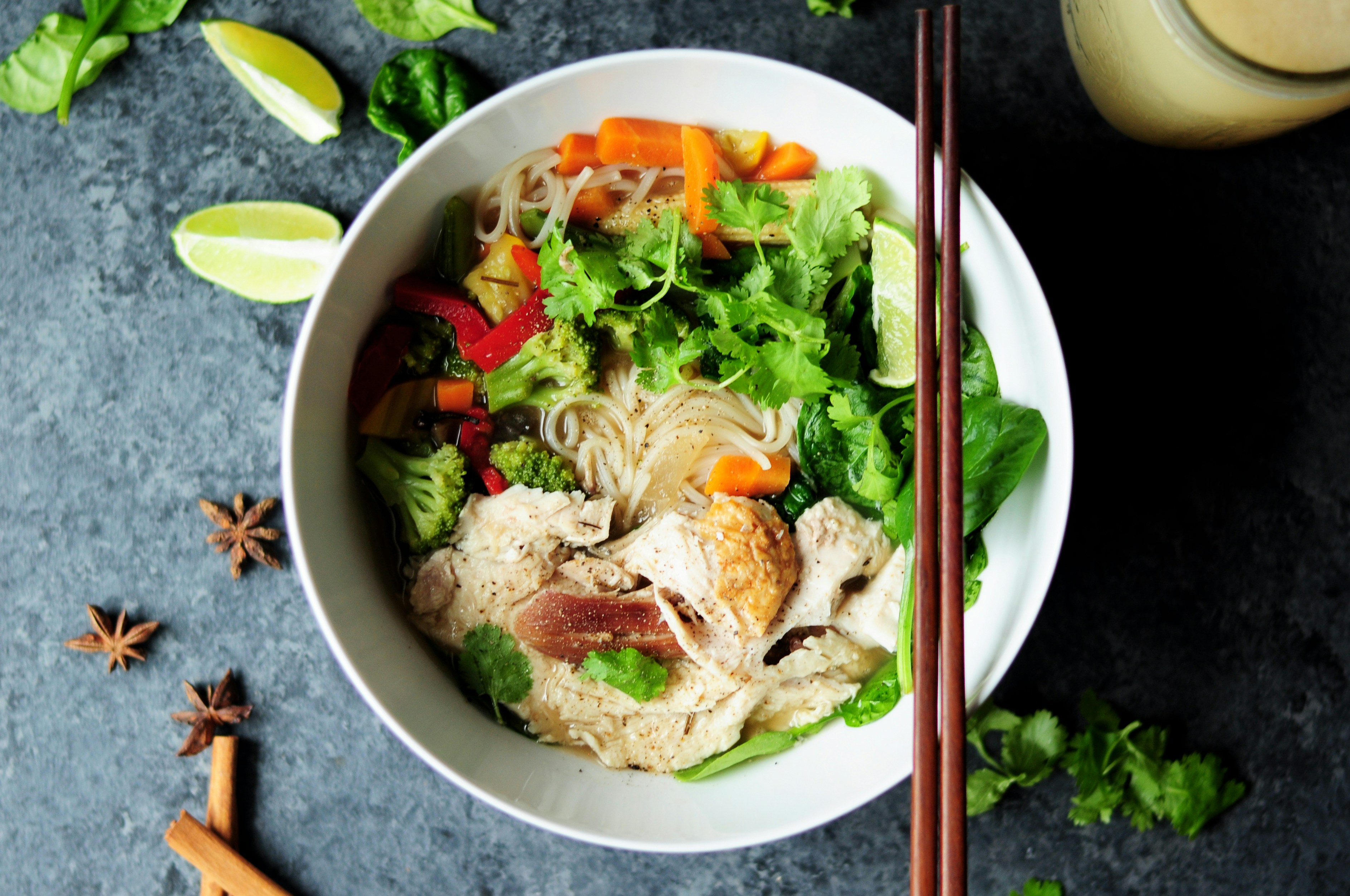 A bowl of delicious noodles with chicken, cilantro, and bean sprouts.